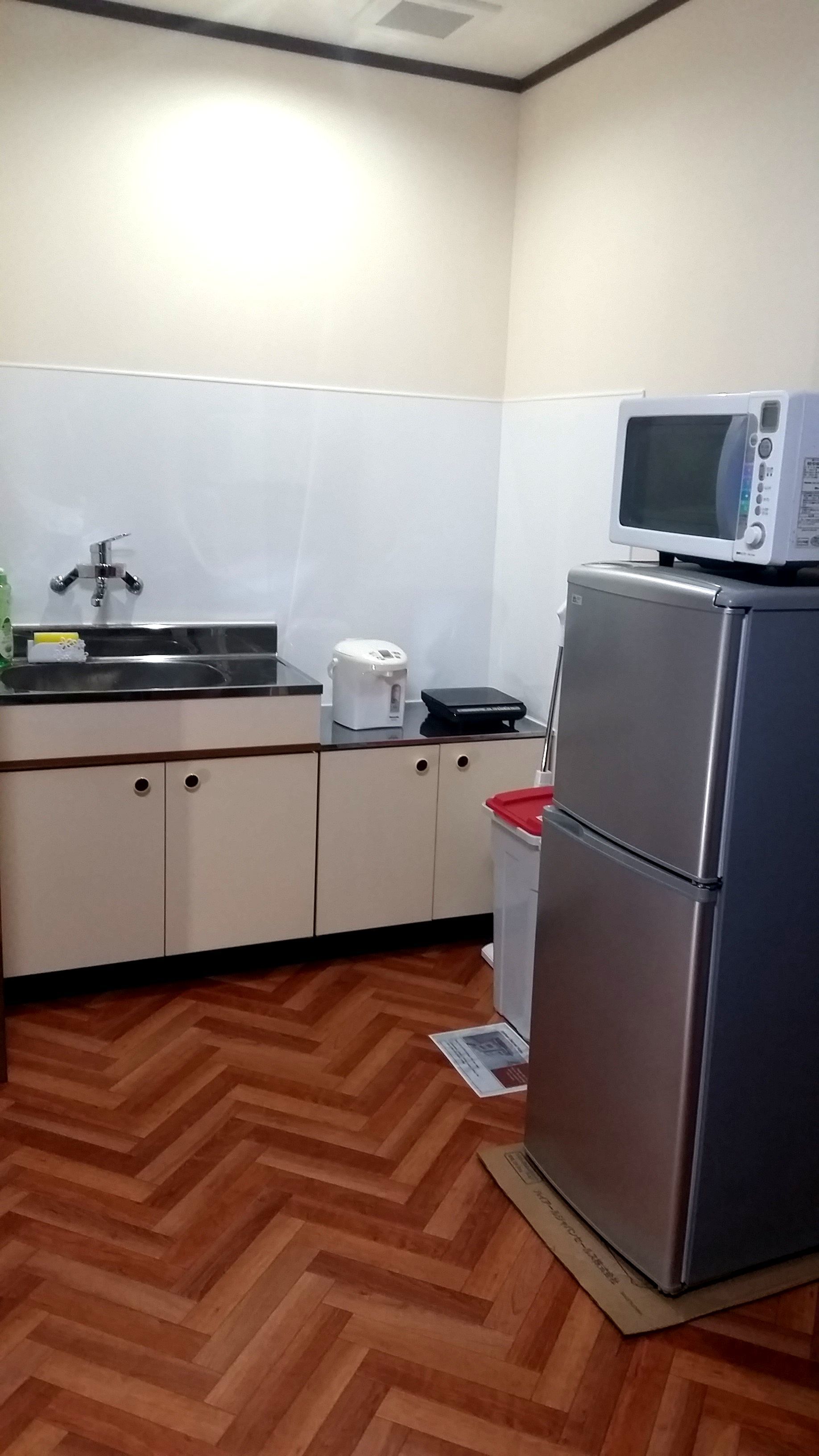 A compact kitchen with a microwave, a toaster, and a refrigerator.