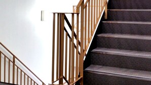 A staircase with wooden railings and carpeted steps. - Mansion Kawata (Osaka)