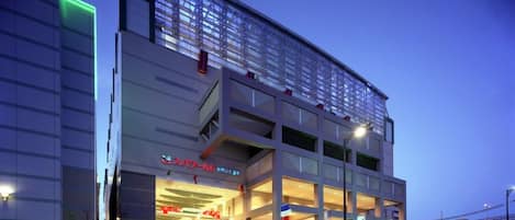 A modern building with a glass facade, multiple levels, and a prominent entrance with steps.
