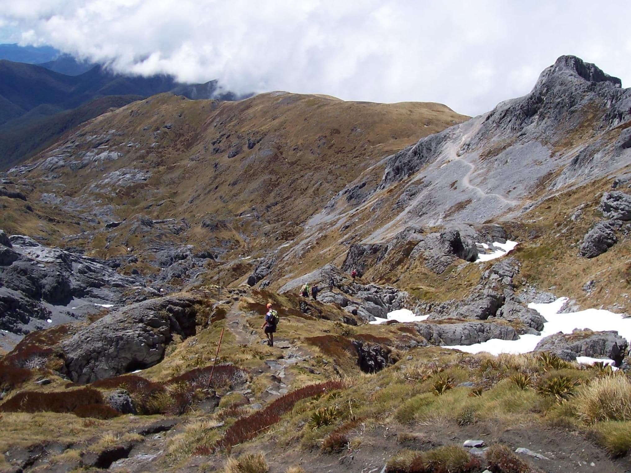 A mountainous landscape with rocky terrain and patches of snow.