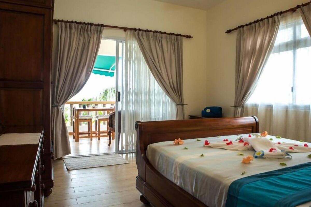 Une chambre d’hôtel avec un lit en bois, un bureau et une vue sur l’extérieur.
