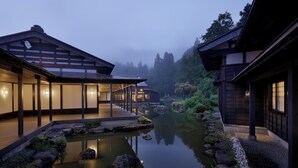 A traditional Japanese-style building with a wooden exterior and a reflection in the water. - ryugon (Minamiuonuma)