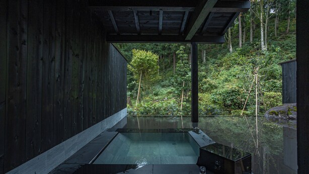 A wooden structure with a glass-enclosed hot tub overlooking a forested area. - ryugon (Minamiuonuma)