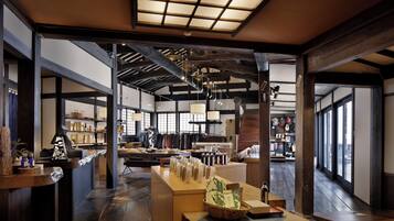 A spacious interior with wooden beams, a reception desk, and a view through large windows.