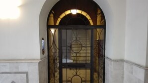 A gated entrance with a decorative iron gate and a small illuminated sign above it. - Relais Villa Borghese (Rome)