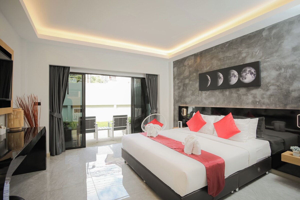 Un dormitorio moderno con una cama grande, vistas al exterior y una obra de arte colgada en la pared representando lunas.
