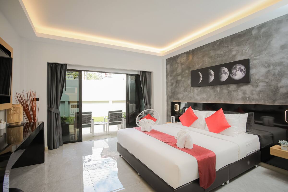 Un dormitorio moderno con una cama grande, vistas al exterior y un cuadro de la luna colgado en la pared.