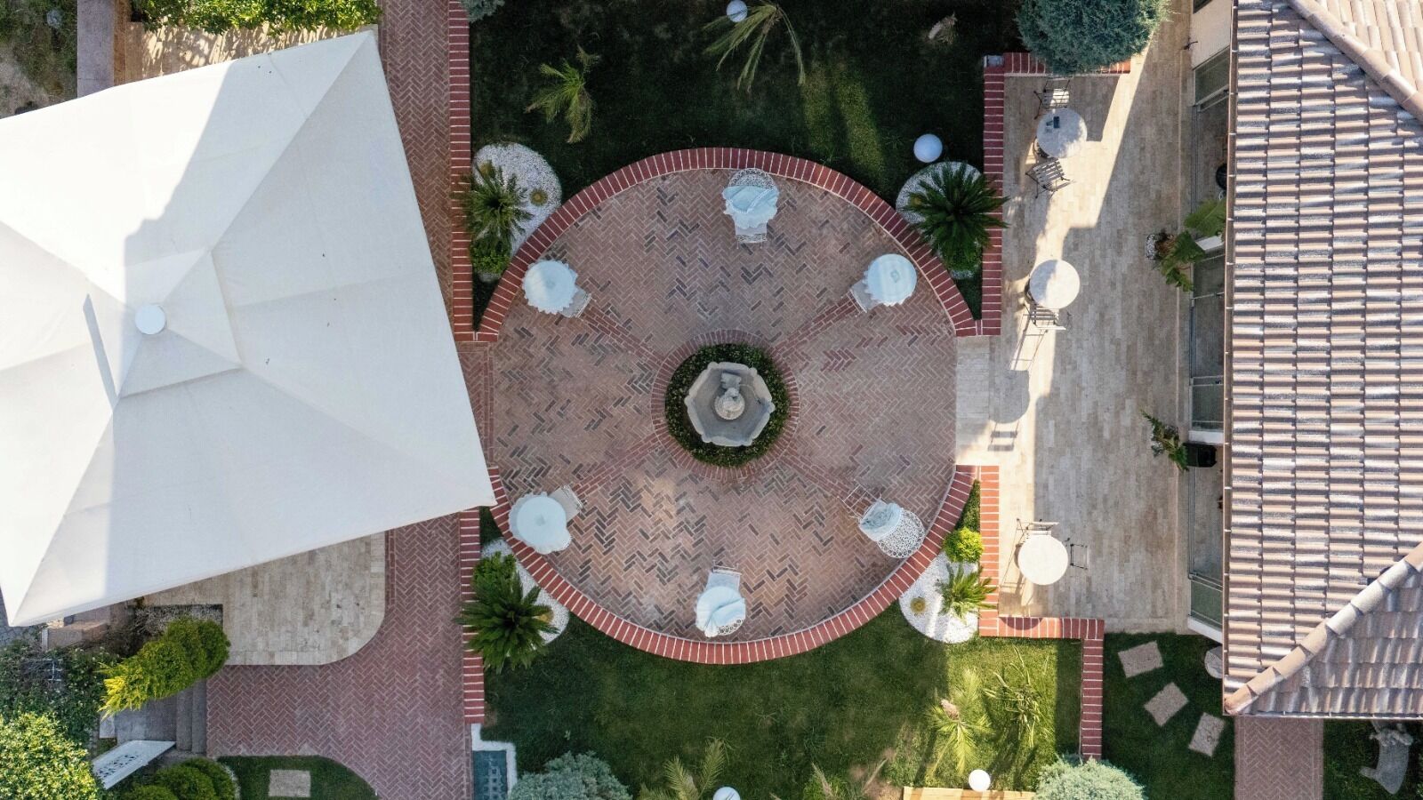 An aerial view of a courtyard with a central fountain, surrounded by seating areas and greenery.