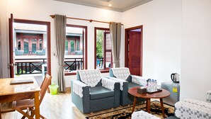 A living room with a sofa set, a dining table, and a coffee machine. - Mei Mei Da Hotel (Siem Reap)