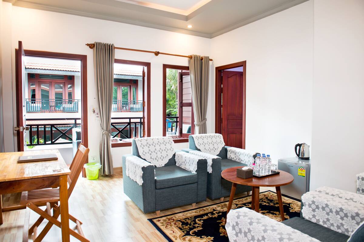 A living room with a sofa set, a dining table, and a coffee machine.