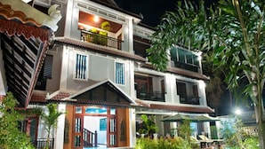 A multi-story building with a traditional architectural style, featuring balconies, a well-maintained garden, and a clear entrance. - Mei Mei Da Hotel (Siem Reap)
