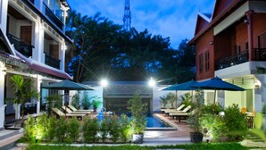 A courtyard with a swimming pool, lounge chairs, and umbrellas. - Mei Mei Da Hotel (Siem Reap)