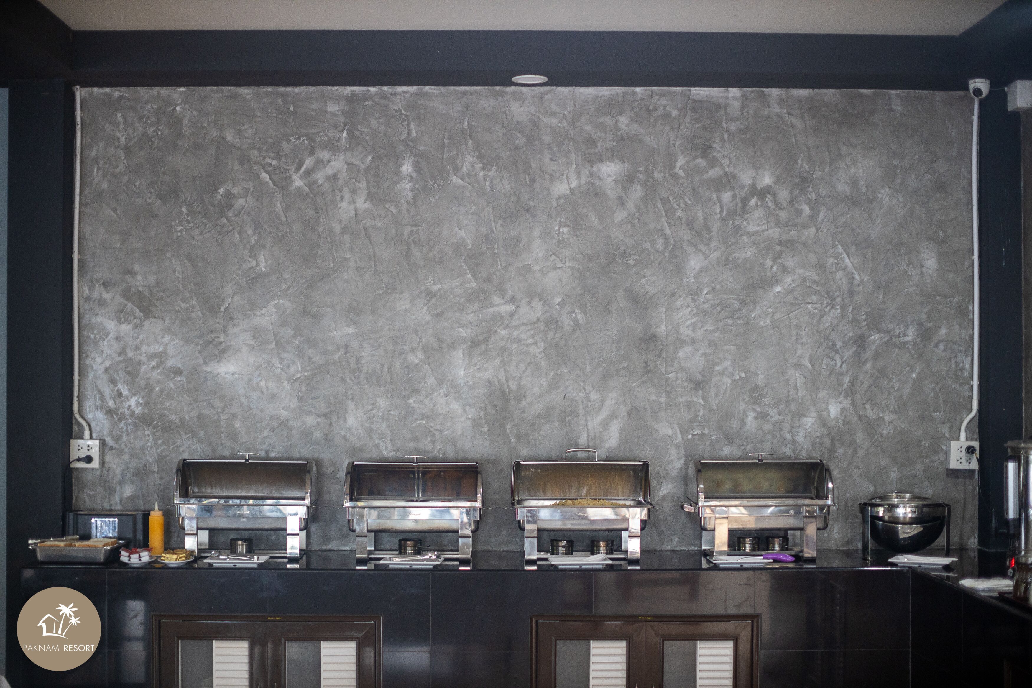 A kitchen area with a marble backsplash and four built-in grills.