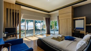 A bedroom with a large bed, a TV, and a view of the beach. - Pak Nam Resort (La-ngu)