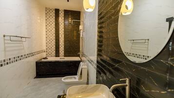 A modern bathroom with a bathtub, toilet, and sink.