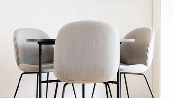 Three modern chairs with metal legs and a round table.