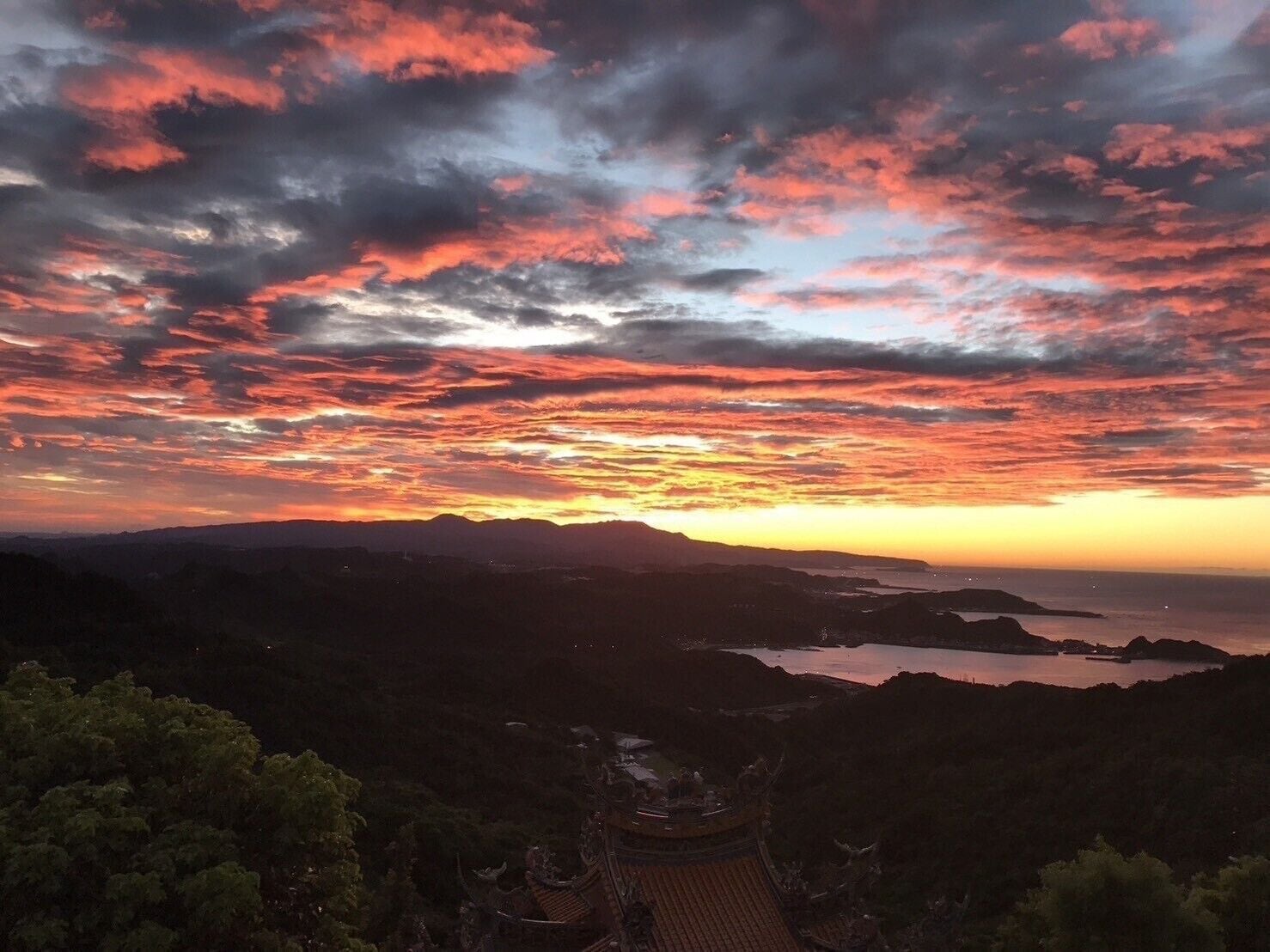 A sunset view with a traditional building in the foreground.