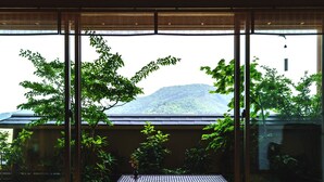 A room with large windows, a tatami mat floor, a low table, and a view of a mountain. - Shiratama no yu KAHOU Bettei Koshinosato (Shibata)