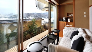 A modern living room with a sofa, a coffee table, and a view of a snowy landscape through large windows. - Shiratama no yu KAHOU Bettei Koshinosato (Shibata)