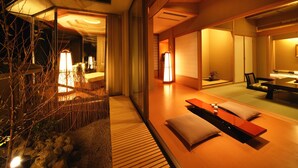 A modern interior with a wooden floor, a seating area with cushions, and a dining table. - Shiratama no yu KAHOU Bettei Koshinosato (Shibata)