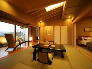 A traditional Japanese-style room with tatami flooring, a low table, and a bed.