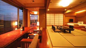 A traditional Japanese-style room with tatami flooring, a low table with cushions, and a bed with a futon. - Shiratama no yu KAHOU Bettei Koshinosato (Shibata)