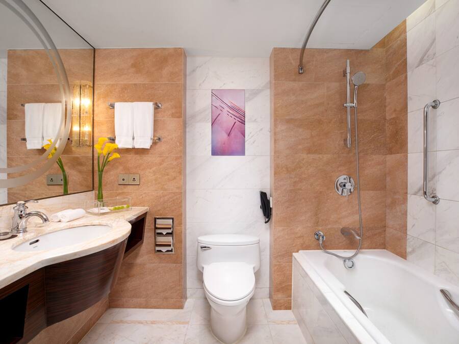 A modern bathroom with a sink, toilet, and bathtub.