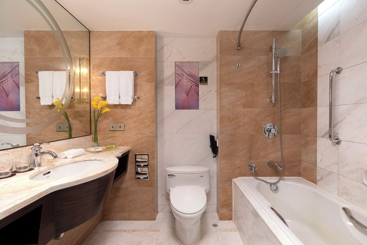 Un baño moderno con una bañera grande, una zona de ducha separada, un inodoro y un tocador con lavabo y espejo.