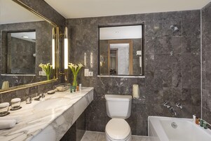 Une salle de bain moderne avec un meuble-lavabo en marbre, des toilettes et une baignoire.