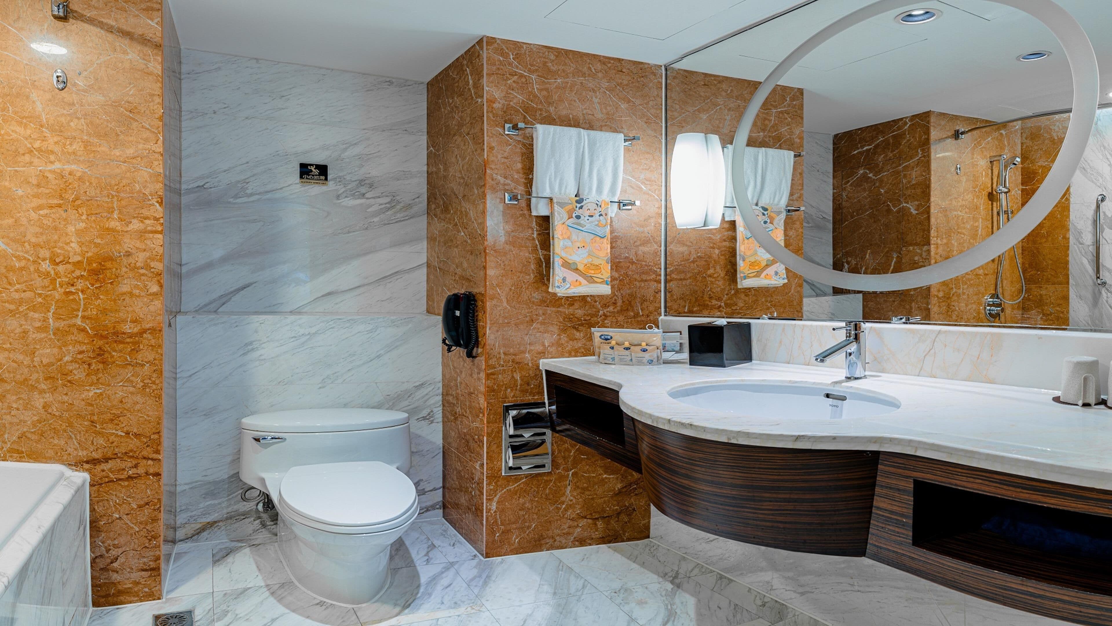 A modern bathroom with a toilet, sink, and bathtub.
