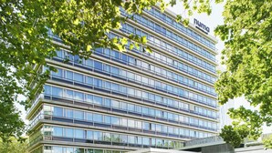 Un immeuble moderne à plusieurs étages, doté d’une façade en verre, d’une enseigne bien visible et d’un toit plat.