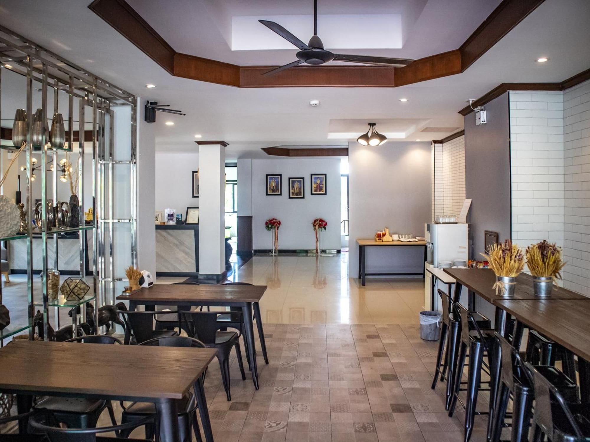 A spacious hotel lobby with a high ceiling, a central seating area, and a bar on the right.