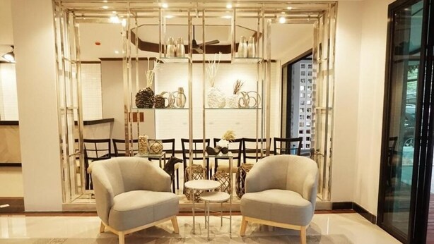 A modern interior with two armchairs, a small round table, and a decorative glass partition with shelves.