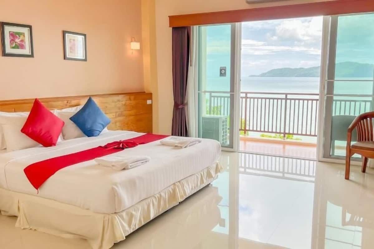 Une chambre d’hôtel avec un lit, une chaise, une table et un balcon offrant une vue.