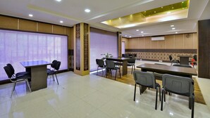 A conference room with a large table and chairs, a projection screen, and a podium.