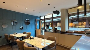 Un intérieur de restaurant moderne avec un mur bleu, des miroirs ronds et un espace bar.