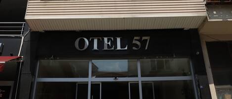 Un edificio de varios pisos con un cartel que dice 'OTEL 57' en la entrada.