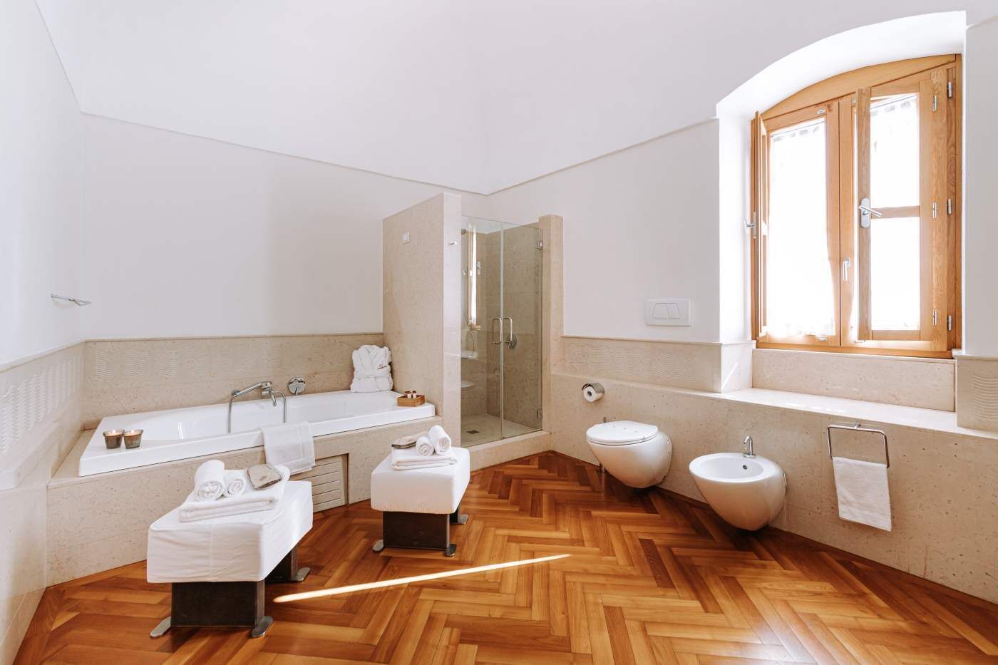 Ein modernes Badezimmer mit einer großen Badewanne, einer Dusche, einer Toilette und einem Waschbecken.