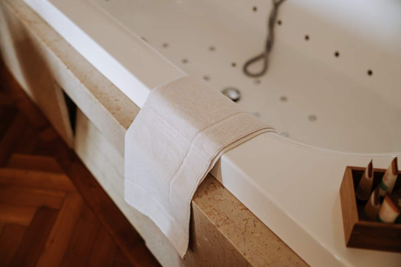 Una bañera con una toalla colgando del borde.