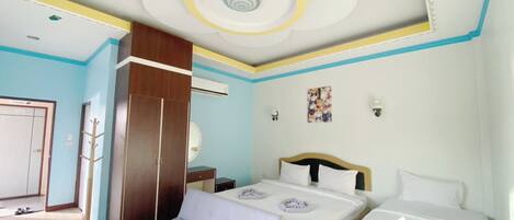 Habitación de hotel con cama, banco, armario y techo con diseño circular.