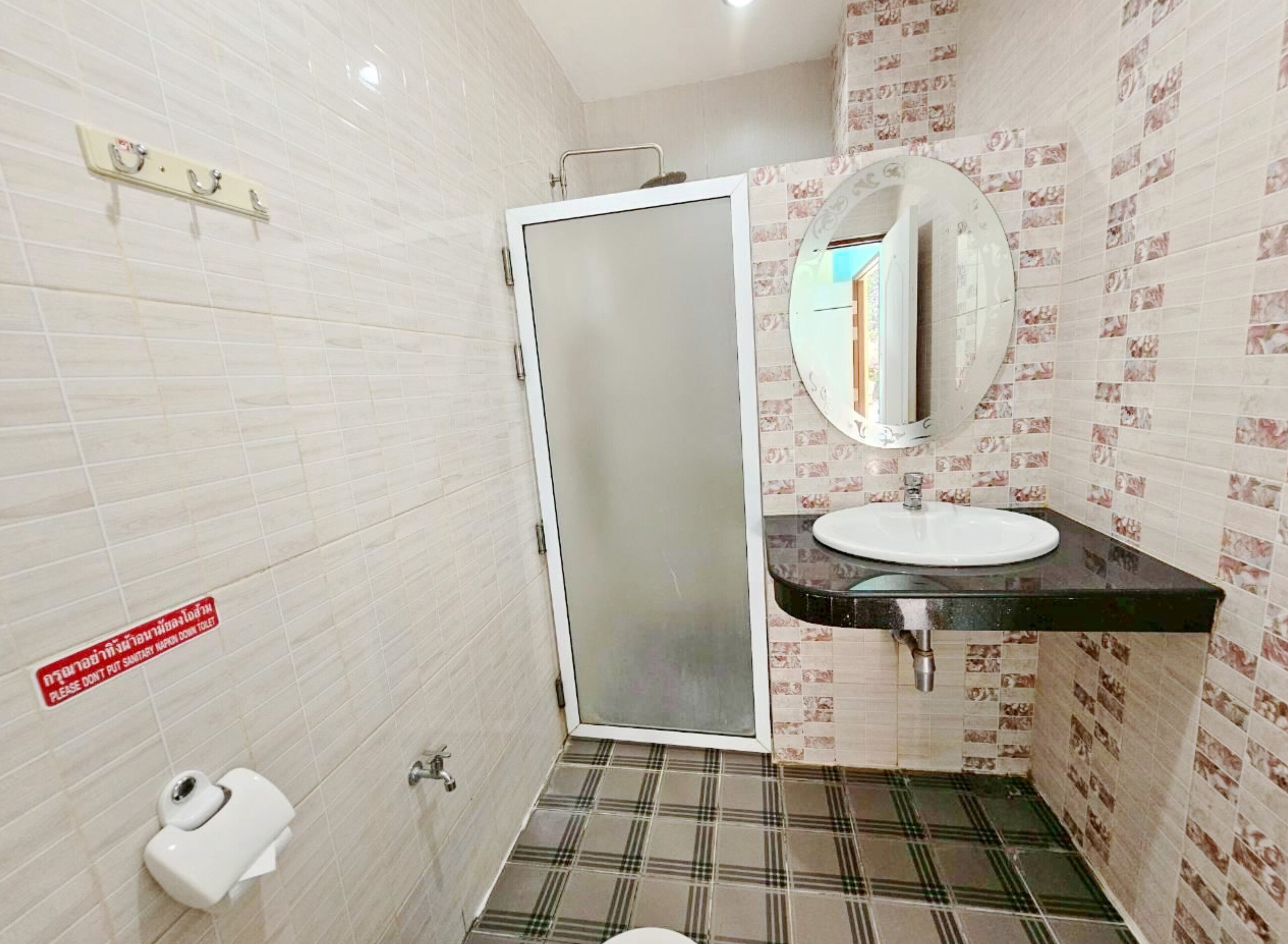 A bathroom with a toilet, sink, and mirror.