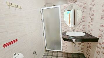 A bathroom with a toilet, sink, and mirror.