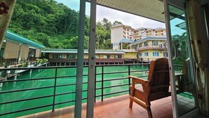 A balcony with a view of a swimming pool and a building complex. - Laketerrace Resort (La-ngu)