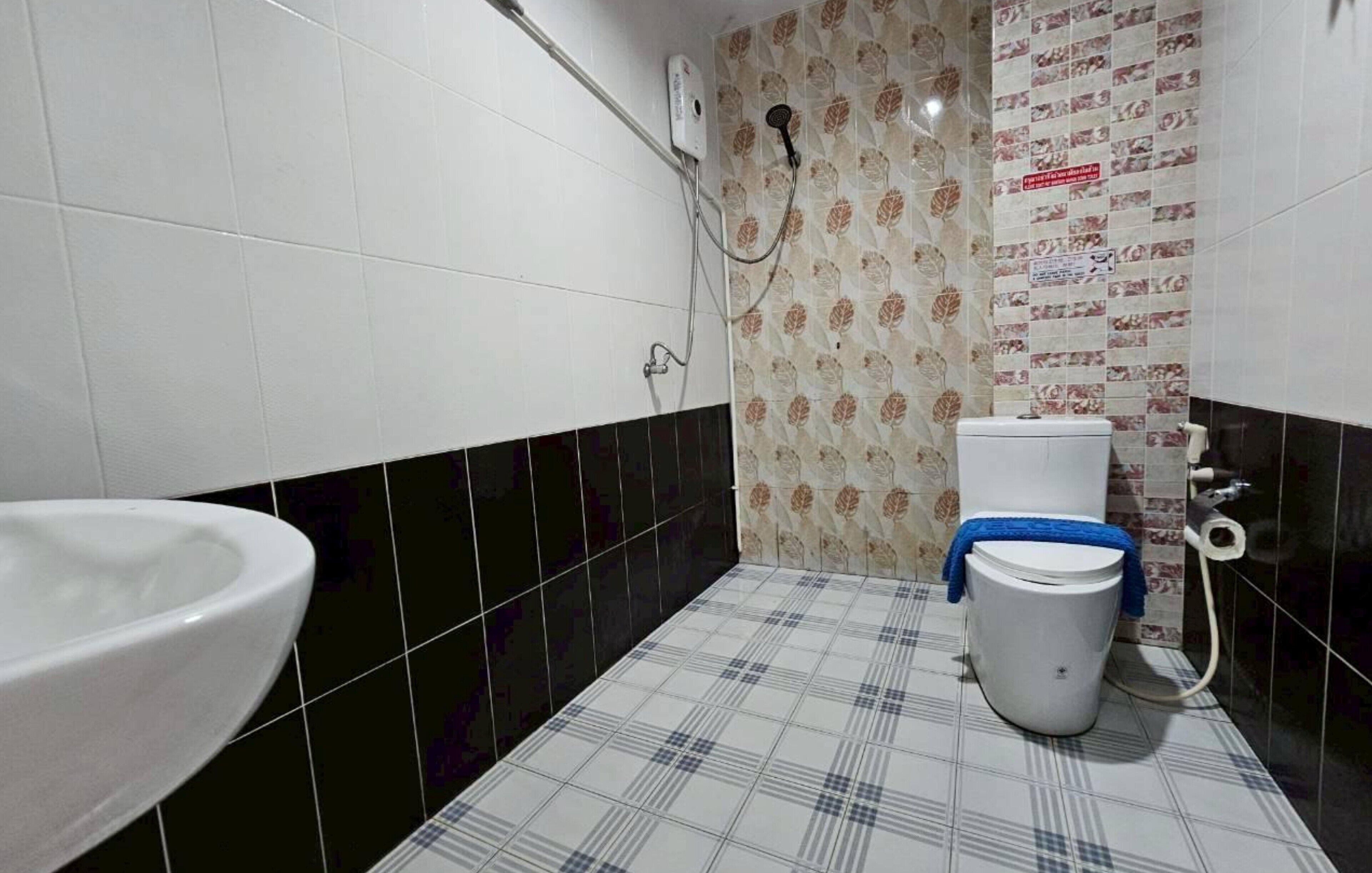 A bathroom with a white toilet, a white sink, and a shower area.