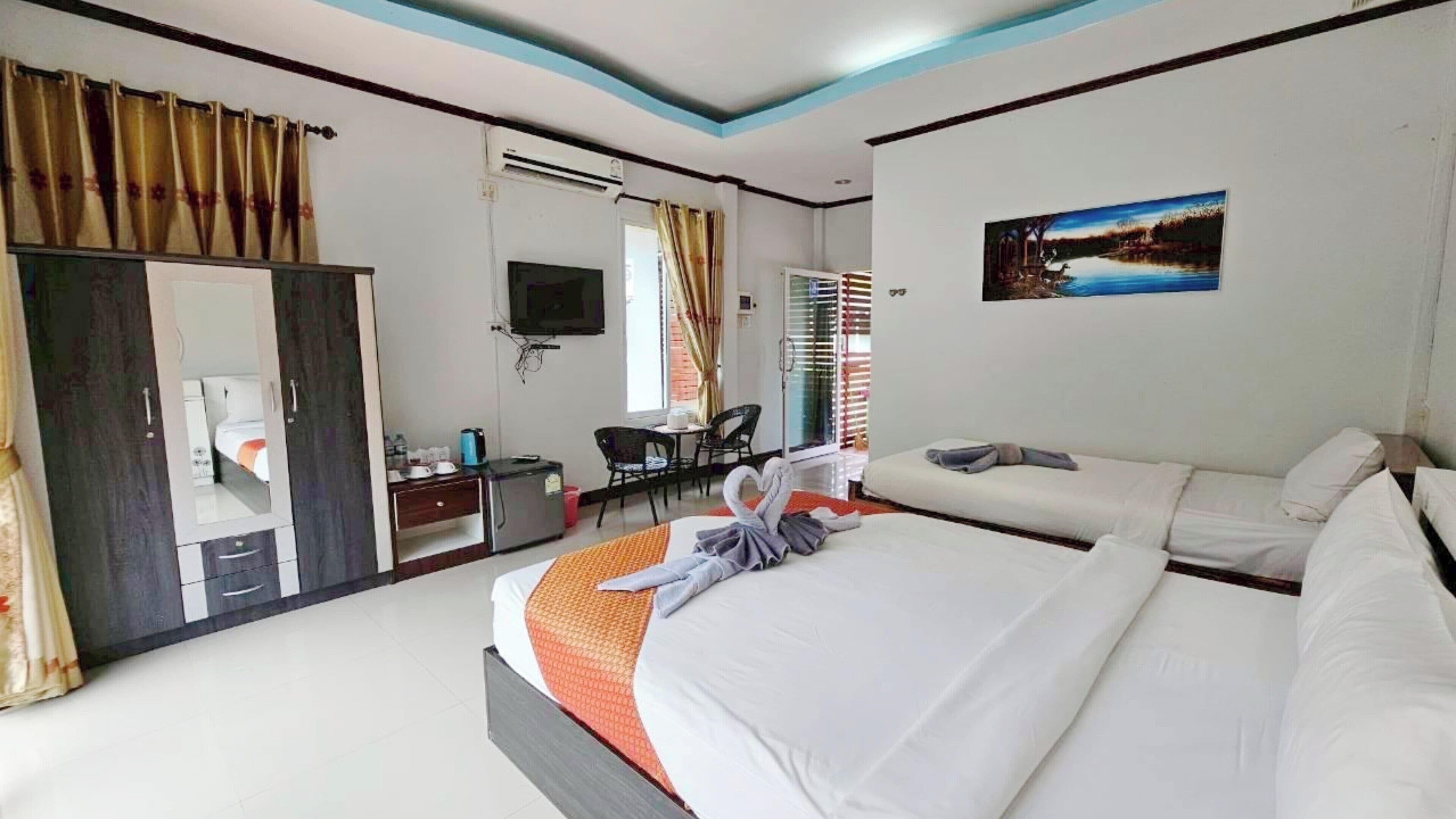 A hotel room with a large bed, a desk with a chair, a TV, and a painting on the wall.