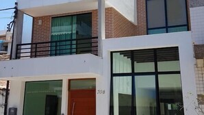 Un edificio moderno de dos pisos con techo plano, ventanas grandes y el número 708 visible.