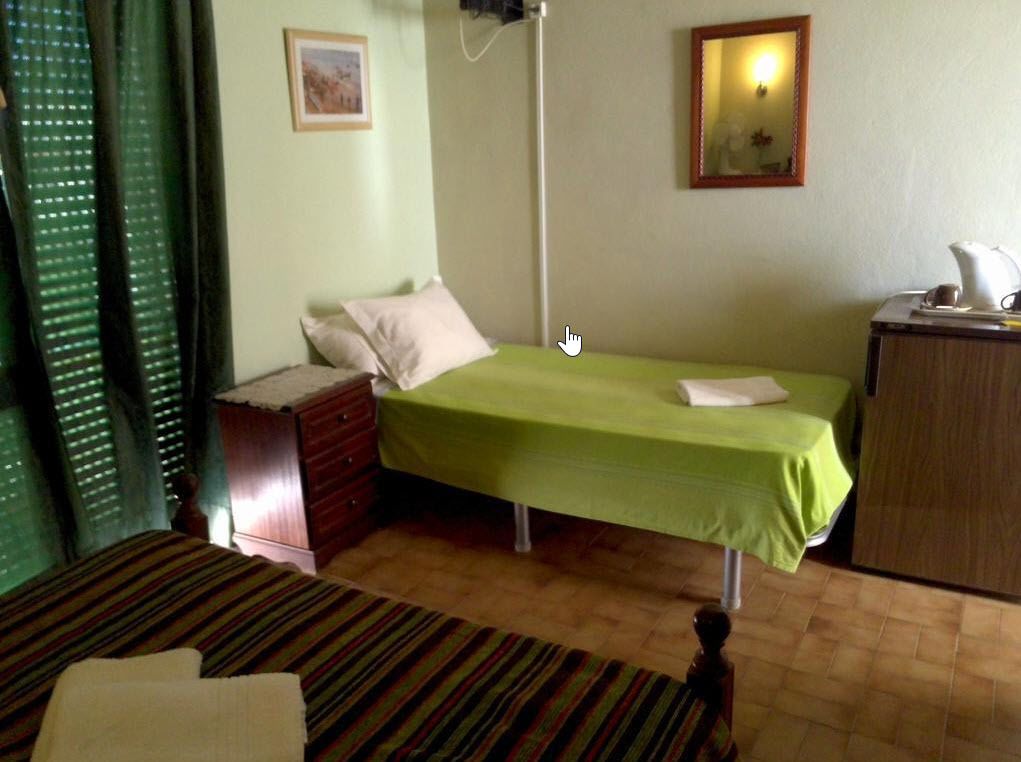 Une pièce comprenant un lit, une commode, un bureau et une lampe.
