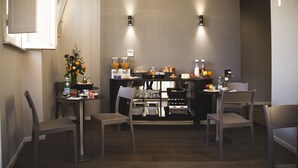 A modern breakfast area with a buffet setup, including various food items and beverages. - Piccola Navona Roof Garden (Rome)