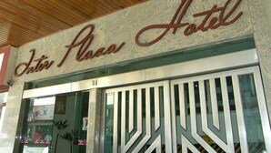 L’extérieur de l’hôtel Inter Plaza, avec sa façade en pierre et son plafond en bois.