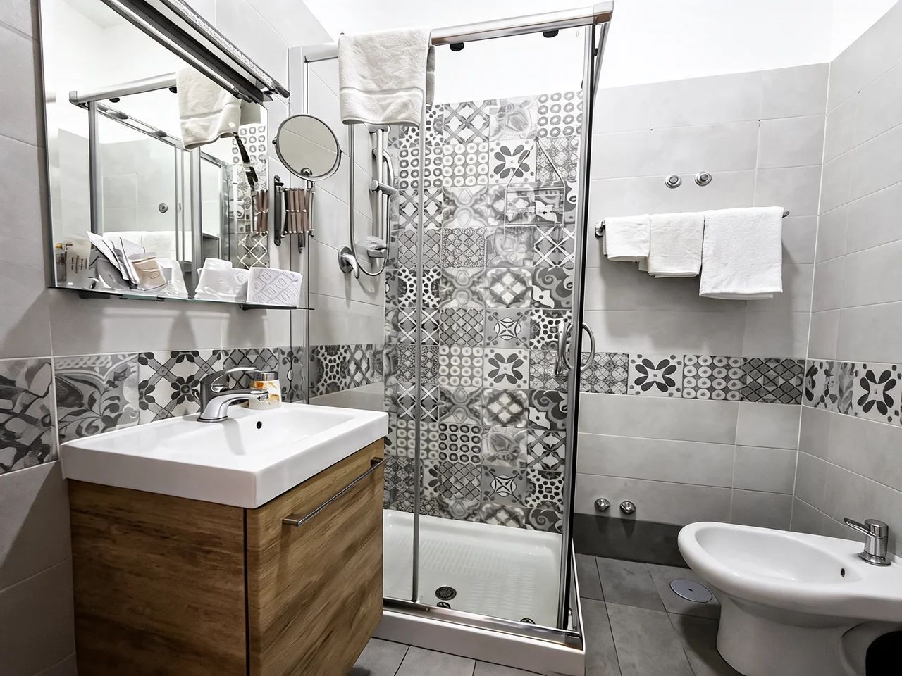 A modern bathroom with a shower, sink, and toilet.